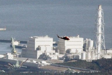 A helicopter flies past Japan's Fukushima Daiichi No.1 Nuclear reactor March 12, 2011. 