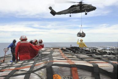 US sailors aboard the U.S. 7th Fleet command ship USS Blue Ridge stand-by to move pallets of humanitarian relief supplies