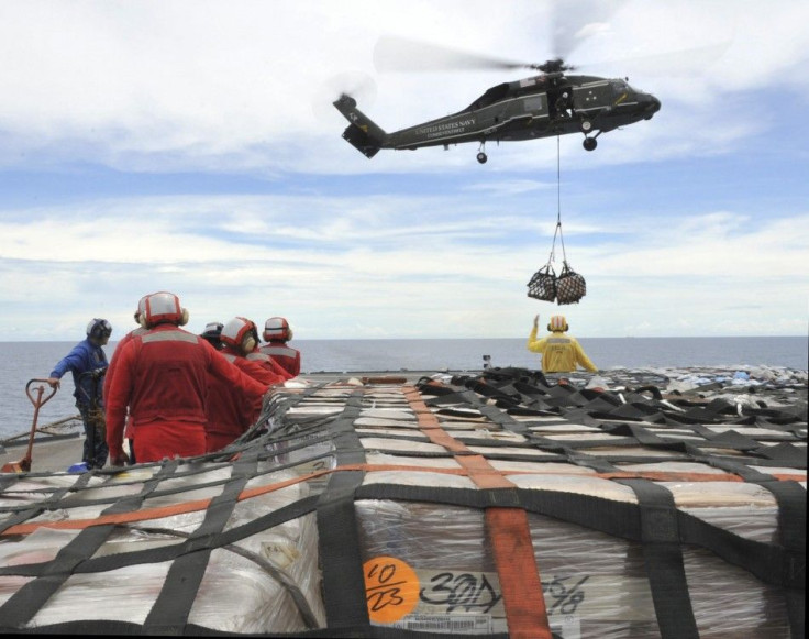 US sailors aboard the U.S. 7th Fleet command ship USS Blue Ridge stand-by to move pallets of humanitarian relief supplies