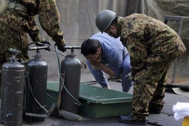 A man who was evacuated from the vicinity of Fukushima nuclear power plant cleanses his face at Japan Ground Self-Defense Forces' (JGSDF) makeshift facility to cleanse people who might be exposed to radiation, in Nihonmatsu, northern Japan March 14, 2011.