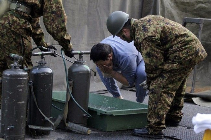 A man who was evacuated from the vicinity of Fukushima nuclear power plant cleanses his face at Japan Ground Self-Defense Forces' (JGSDF) makeshift facility to cleanse people who might be exposed to radiation, in Nihonmatsu, northern Japan March 14, 2011.