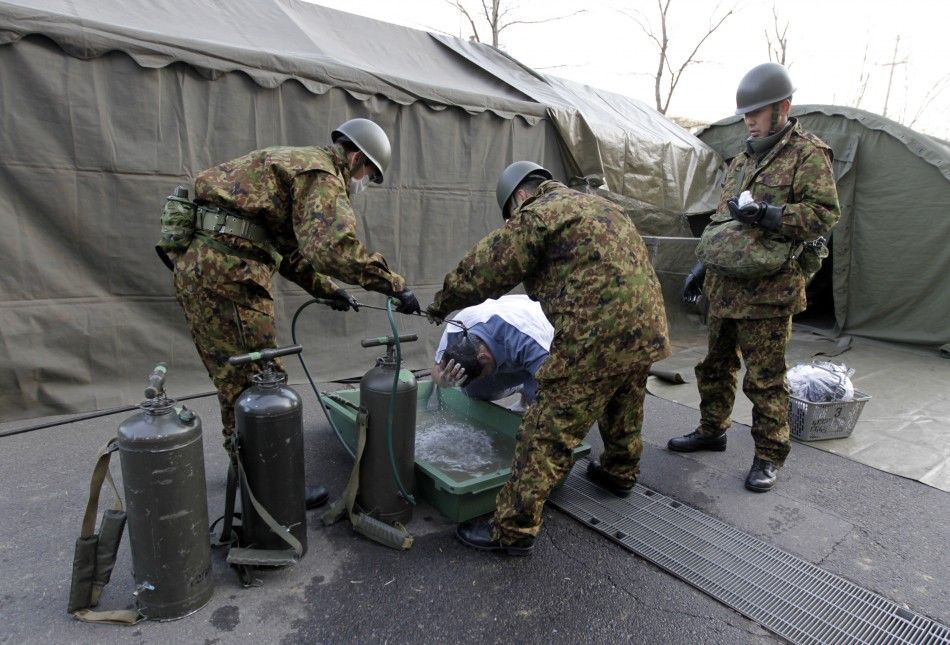 Man who was evacuated from vicinity of Fukushimas nuclear power plant washes his head at JGSDFs makeshift facility to cleanse people who might have been exposed to radiation in Nihonmatsu