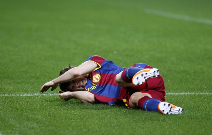 Barcelona's Messi grimaces in pain after a tackle during their Spanish first division soccer match against Sevilla in Seville.