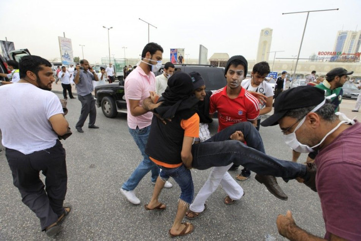 Anti-government protesters carry an injured protester during clashes with the police in Manama