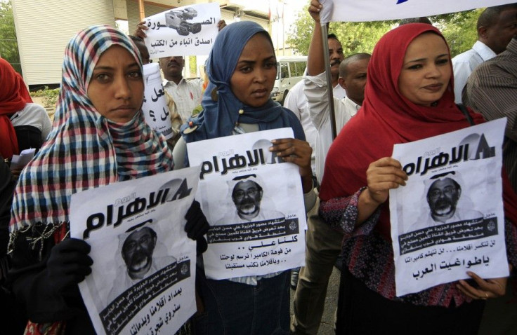 Protesters hold pictures of Al Jazeera cameramen Ali Hassan al-Jaber during a rally against the assassination of journalists in Khartoum