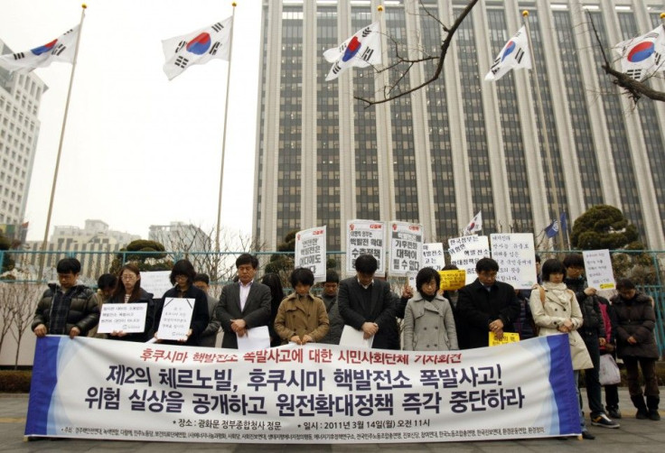 Environmental activists pay silent tribute to victims of earthquake and tsunami in Japan during rally demanding South Korean government halt building of more nuclear plants in South Korea, in Seoul