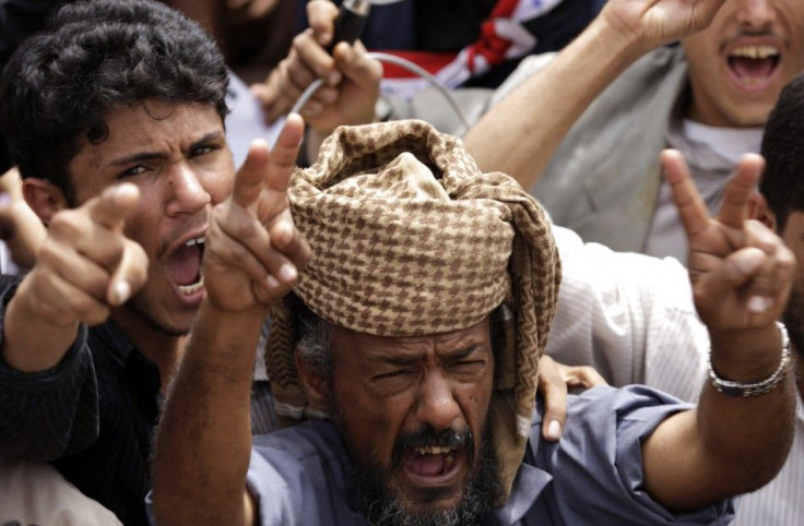 Anti-government protesters shout slogans during a rally outside Sanaa University