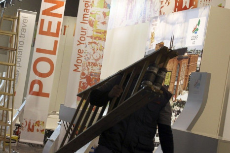 A worker carries a ladder at the Polish booth during final preparations at the international tourism industry fair in Berlin.