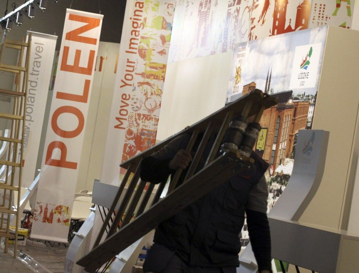A worker carries a ladder at the Polish booth during final preparations at the international tourism industry fair in Berlin.