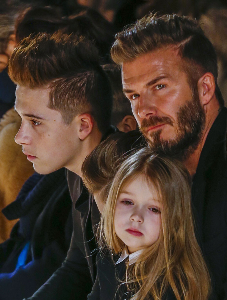 [8:50] Former England captian David Beckham sits with his son, Brooklyn (L) and his daughter, Harper, during a presentation of the Victoria Beckham Fall/Winter 2015 collection during New York Fashion Week