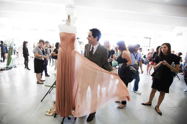 [20:53] Designer Zac Posen looks at a creation before a presentation of his Spring/Summer 2014 collection