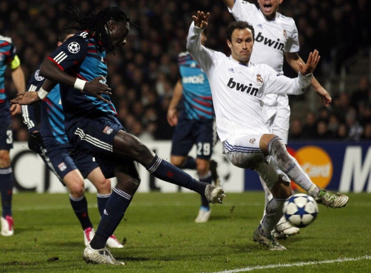 Olympique Lyon's Gomis shoots to score against Real Madrid as Real Madrid's Carvalho looks on during their Champions League soccer match in Lyon