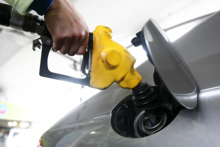 An attendant tops up petrol for a vehicle at a gas station