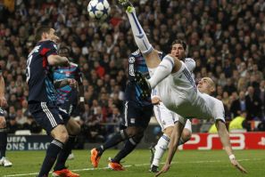 Real Madrid's Benzema tries to kick the ball challenged by Olympique Lyon's Reveillere during their Champions League soccer match in Madrid.