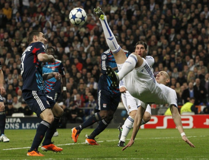 Real Madrid's Benzema tries to kick the ball challenged by Olympique Lyon's Reveillere during their Champions League soccer match in Madrid.