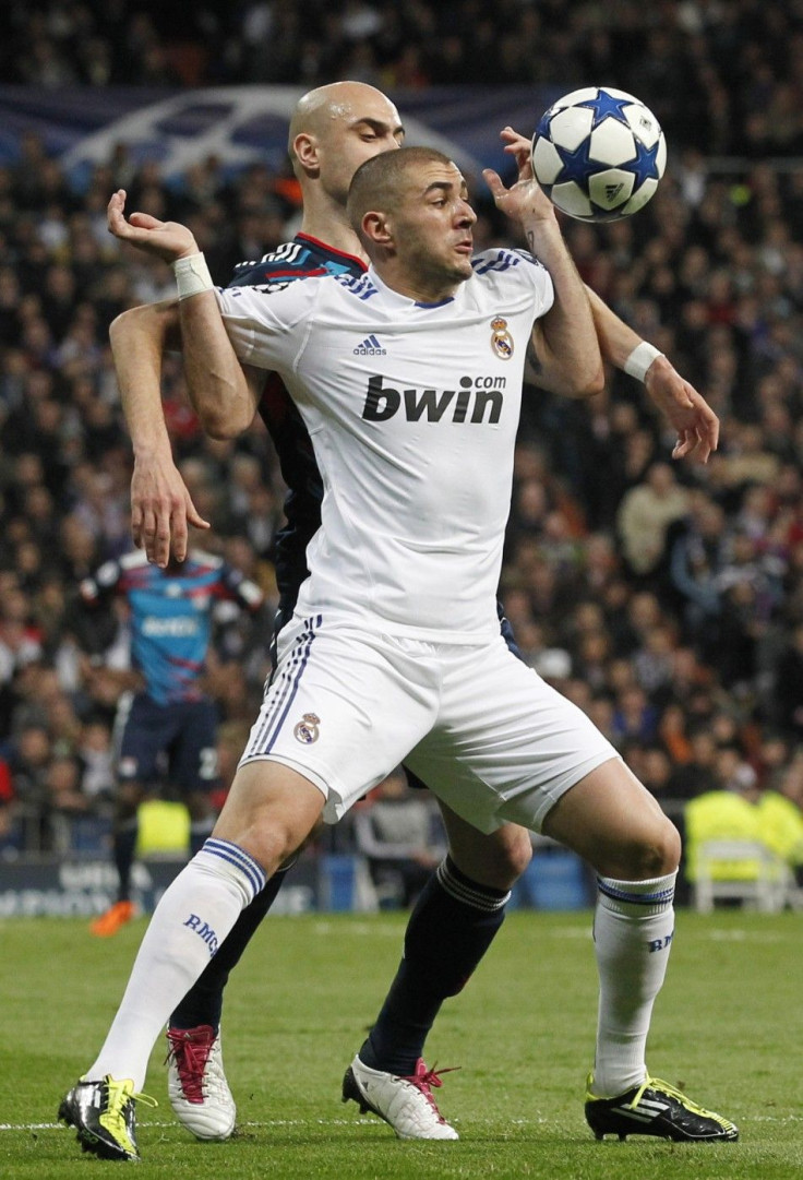 Real Madrid's Benzema is grabbed by Olympique Lyon's Cris during their Champions League soccer match in Madrid.