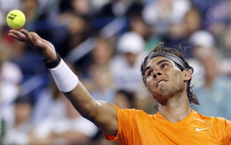 Nadal tosses the ball to serve against Devvarman during their match at the Indian Wells ATP tennis tournament in Indian Wells.