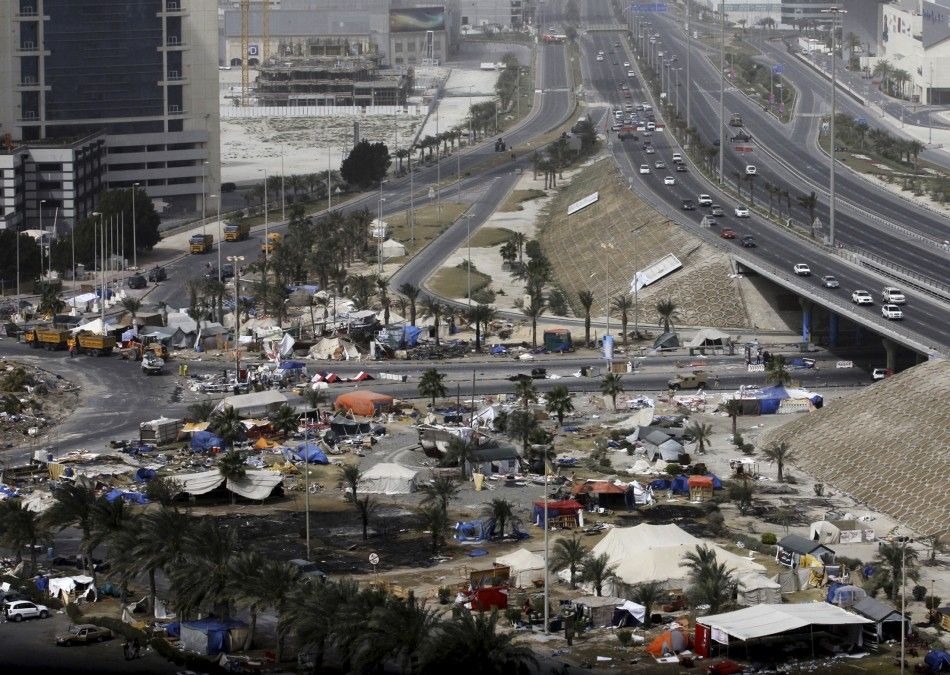 Cars line up at a checkpoint as heavy machinery clears the opposition camp in Pearl Square in Manama