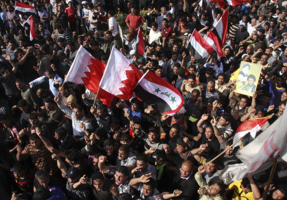 Protesters hold up Iraqi and Bahraini flags during a demonstration in Baghdads Sadr city, in support of the Bahraini people