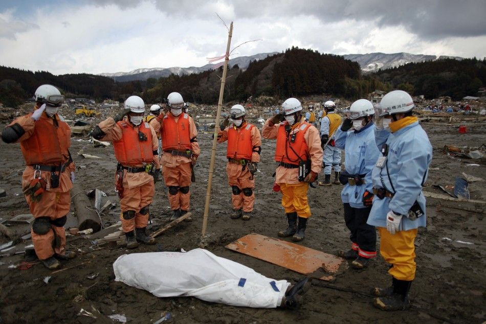 Rescue workers salute next to a body they retrieved from the rubbles in Rikuzentakat, days after the area was devastated by a magnitude 9.0 earthquake and tsunami March 17, 2011. 