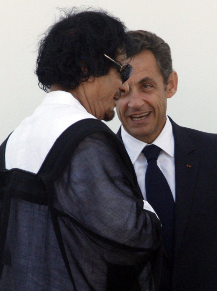 Libya's leader Gaddafi speaks with France's President Sarkozy as he leaves the final meeting at the G8 summit in L'Aquila  10/07/2009