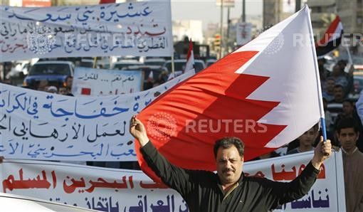 A resident holds up the Bahraini flag as he demonstrates in support of the Bahraini people in central Baghdad