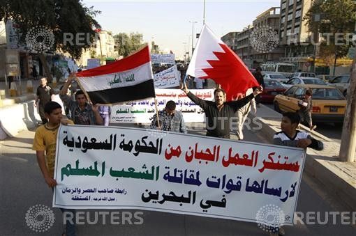 Residents hold up Bahraini and Iraqi flags during a demonstration in central Baghdad. 