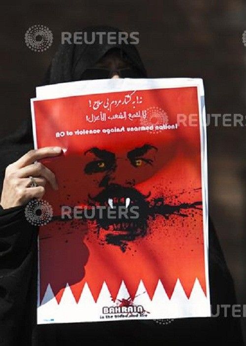 A demonstrator protesting the presence of the Saudi Arabian military in Bahrain holds a placard in front of the Saudi embassy in Tehran