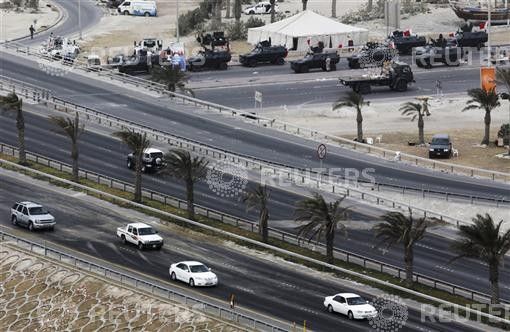 Cars drive on Pearl Square flyover after protesters were cleared in a crackdown in Manama