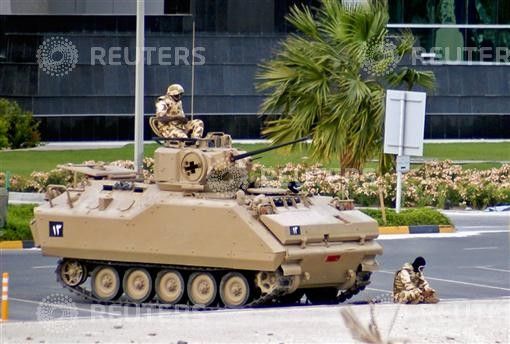 A soldier from the Gulf Cooperation Council GCC forces prays in front of his Armour Personnel Carrier in Manama