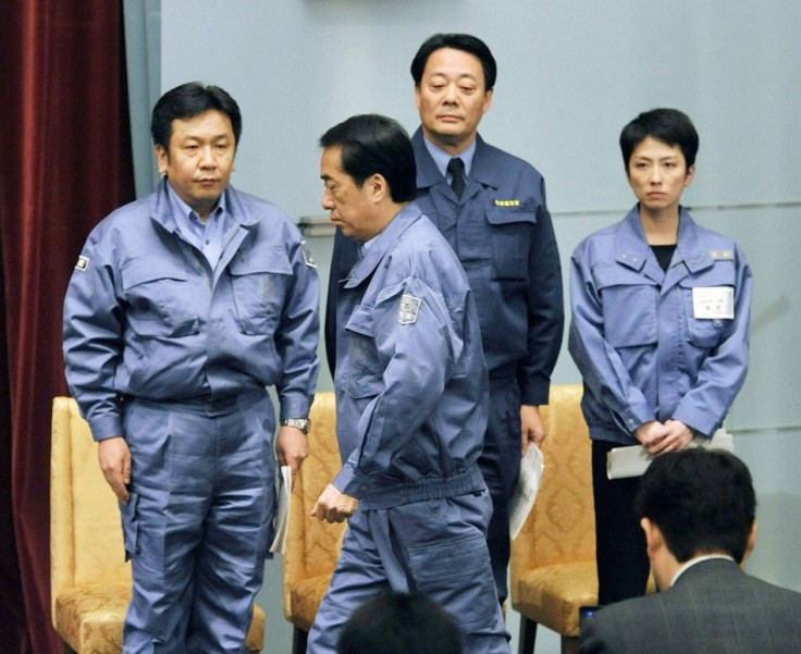 Japan's PM Kan walks past his ministers toward the podium before a news conference at his official residence in Tokyo