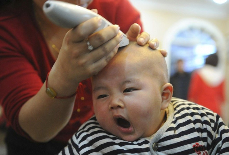 A baby yawns while getting a haircut at a barbershop in China