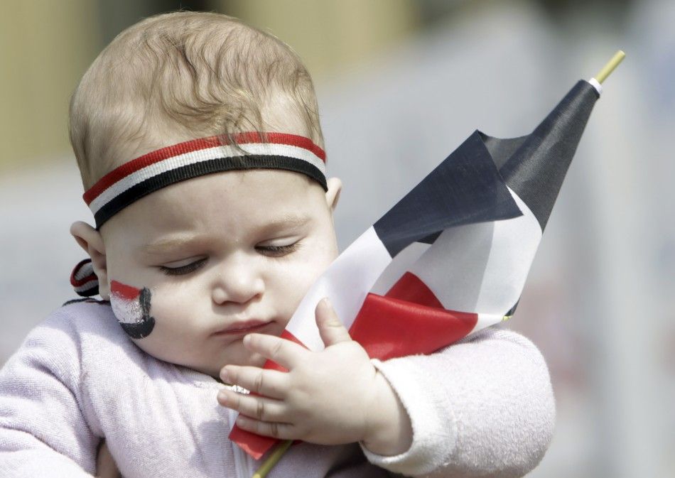 A baby holds an Egyptian flag at Tahrir Square in Cairo
