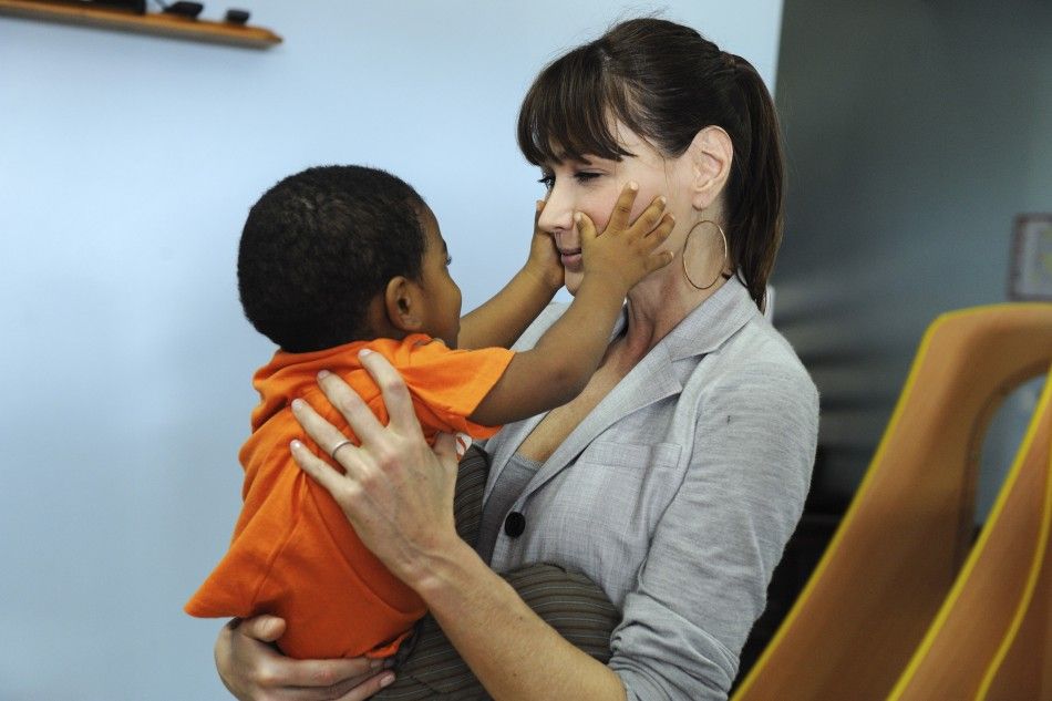 Frances First Lady Carla Bruni carries a boy as she visits a child care center in Le Lamentin on the French Carribbean island of Guadeloupe
