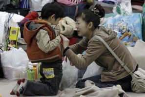 A mother touches her son's stomach at an evacuation center set in a gymnasium in Yamagata, northern Japan