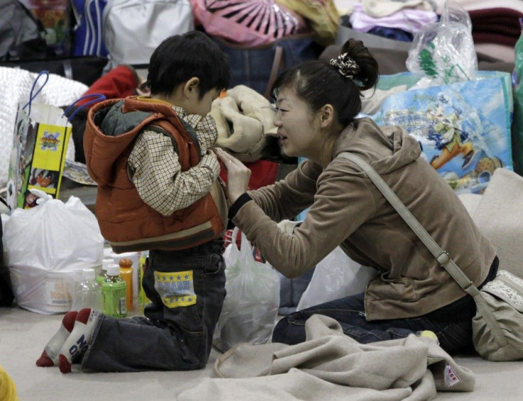 A mother touches her son's stomach at an evacuation center set in a gymnasium in Yamagata, northern Japan