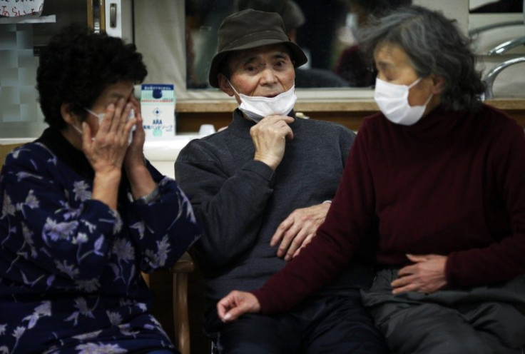 Elderly Japanese people are seen wearing face masks at a collective shelter for earthquake and tsunami survivors in Rikuzentakat