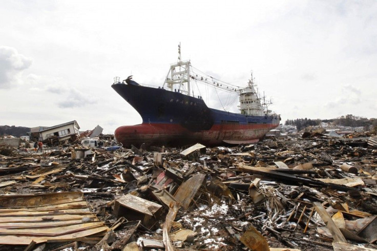 A police officer stands at an area destroyed by an earthquake and a tsunami in kesennuma city