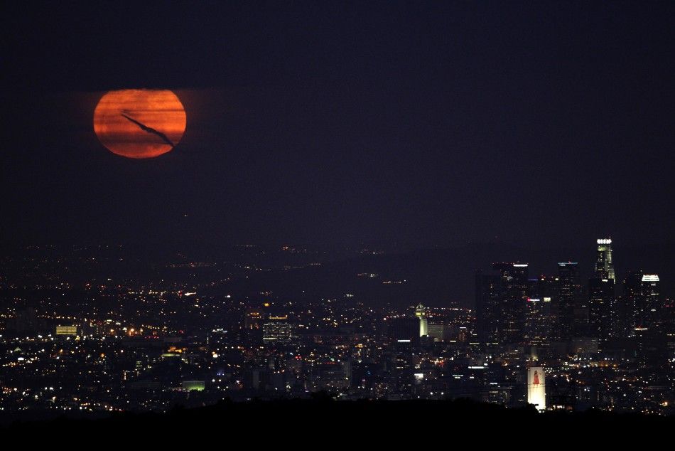 The moon rises over downtown Los Angeles