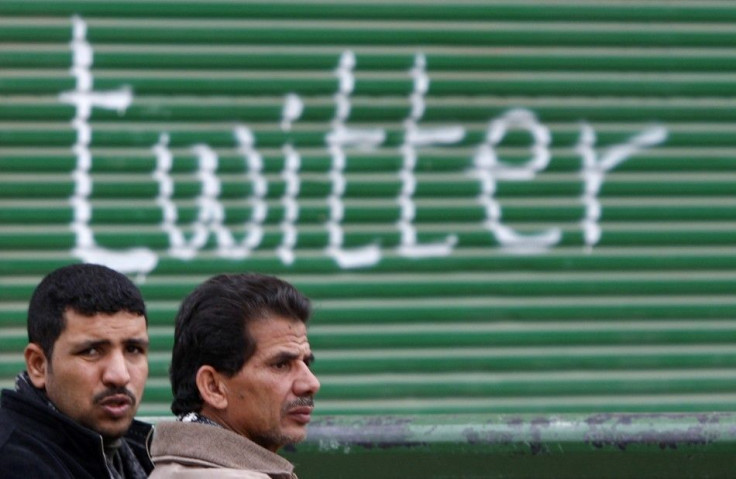 Opposition supporters talk near graffiti referring to the social networking site &quot;Twitter&quot; in Tahrir Square in Cairo February 5, 2011.
