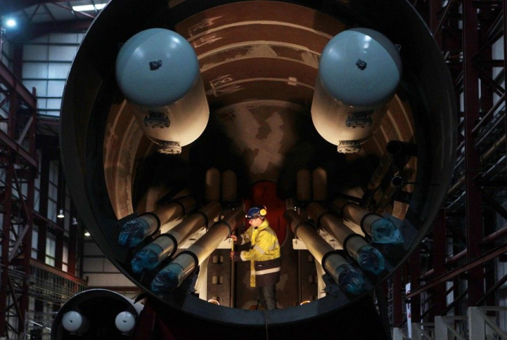 An engineer works inside a section of a Pelamis wave energy converter at their factory in Edinburgh, Scotland.