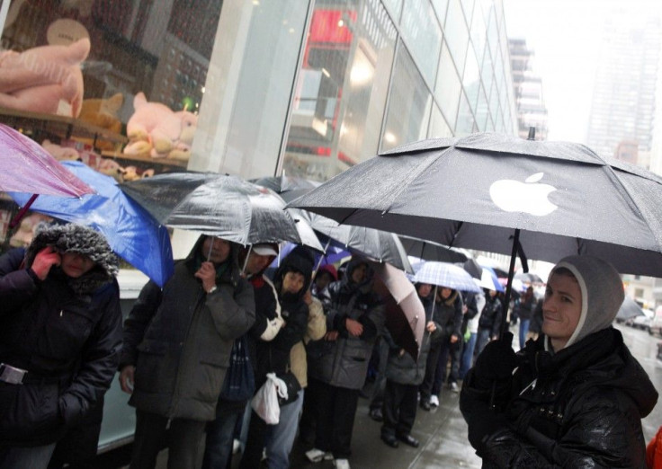 An employee (R) looks at customers stand in line outside Apple's flagship 5th Avenue store to purchase iPad 2 tablets in New York, March 16, 2011.