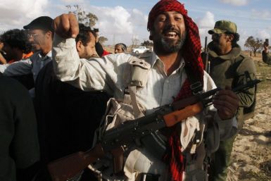 A rebel celebrates at the road between Benghazi and Ajdabiyah