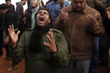 Mourners react next to grave of a rebel killed by forces loyal to Libyan leader Muammar Gaddafi in Ajdabiyah, during his funeral in Benghazi