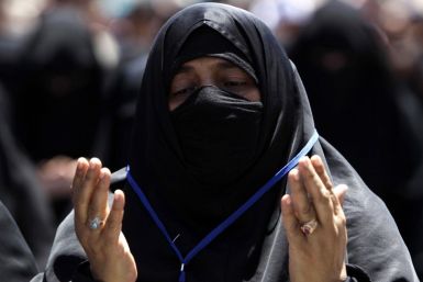A woman recites prayers during a rally to demand the ouster of Yemen's President Ali Abdullah Saleh outside Sanaa