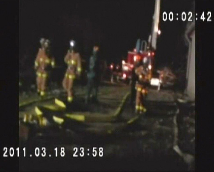 Firefighters wearing respirators work at the Fukushima nuclear plant in this still image taken from video