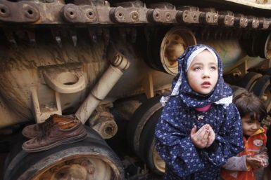 A girl attends Friday prayers in front of an army tank in Tahrir Square in Cairo