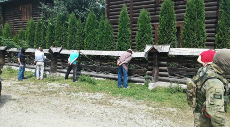 Members of a criminal gang stand in the stress position after being arrested by Ukrainian security services. 