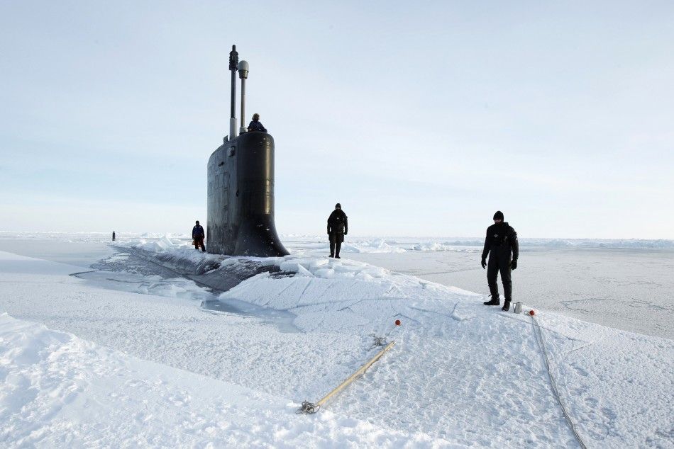 U.S. Navy safety swimmers stand on the deck of the Virginia class submarine USS New Hampshire after it surfaced in the Arctic Ocean north of Prudhoe Bay