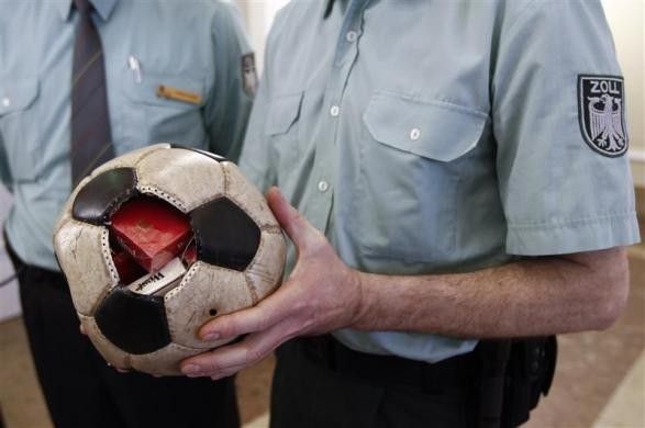A German customs officer holds a confiscated soccer ball
